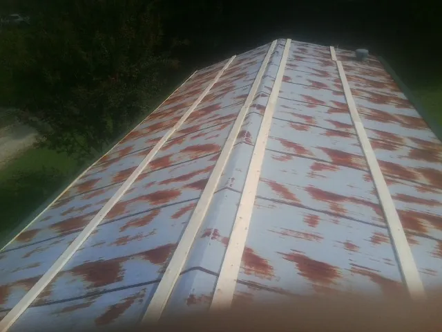 Rusted metal roof panels with new wood purlins before replacement — Storm Damage Roof Repair in Mill City by Roofing Brothers