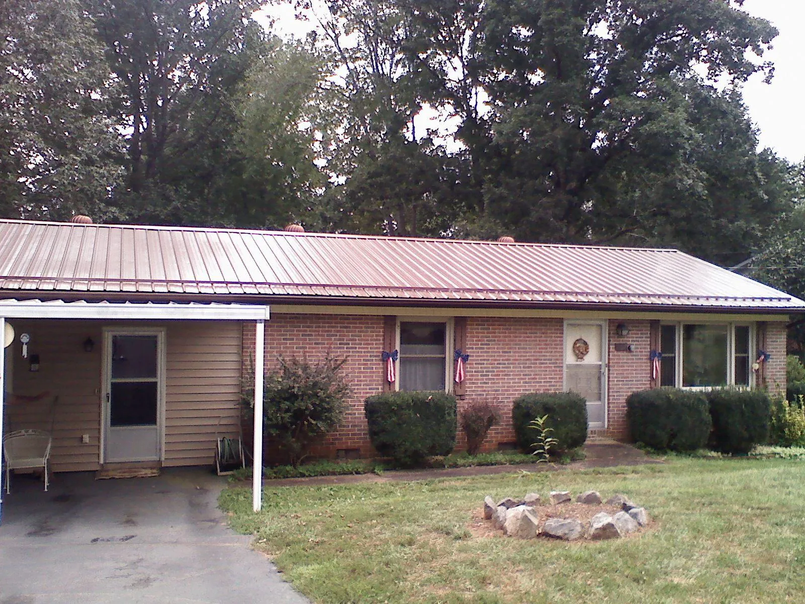 Bronze metal roof and carport on a brick ranch home — Roof Repair work by our crew in Mill City